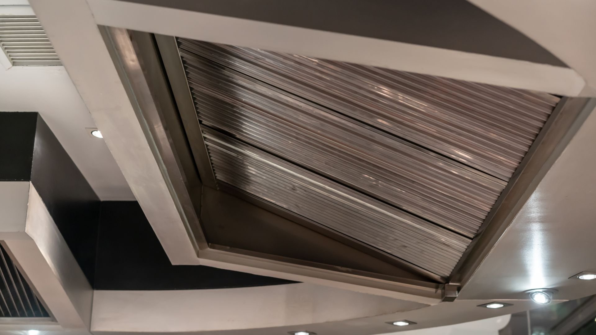 Modern architectural ceiling with geometric angles and metallic ribbed skylight