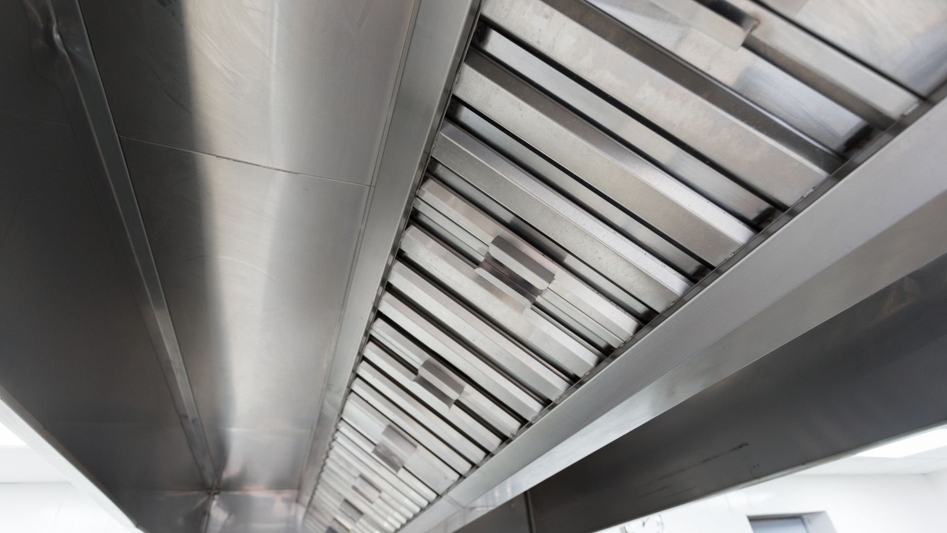 Stainless steel kitchen ventilation hood with metallic geometric pattern
